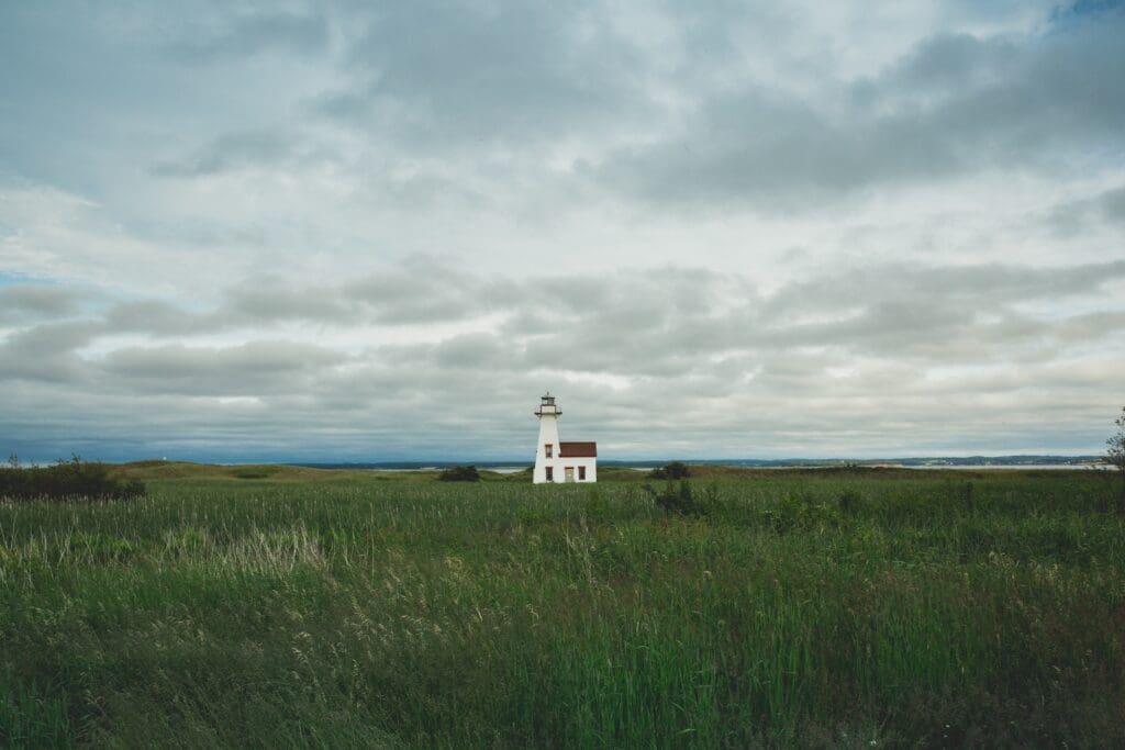 Lighthouse in field with coast in background on Price Edward Island