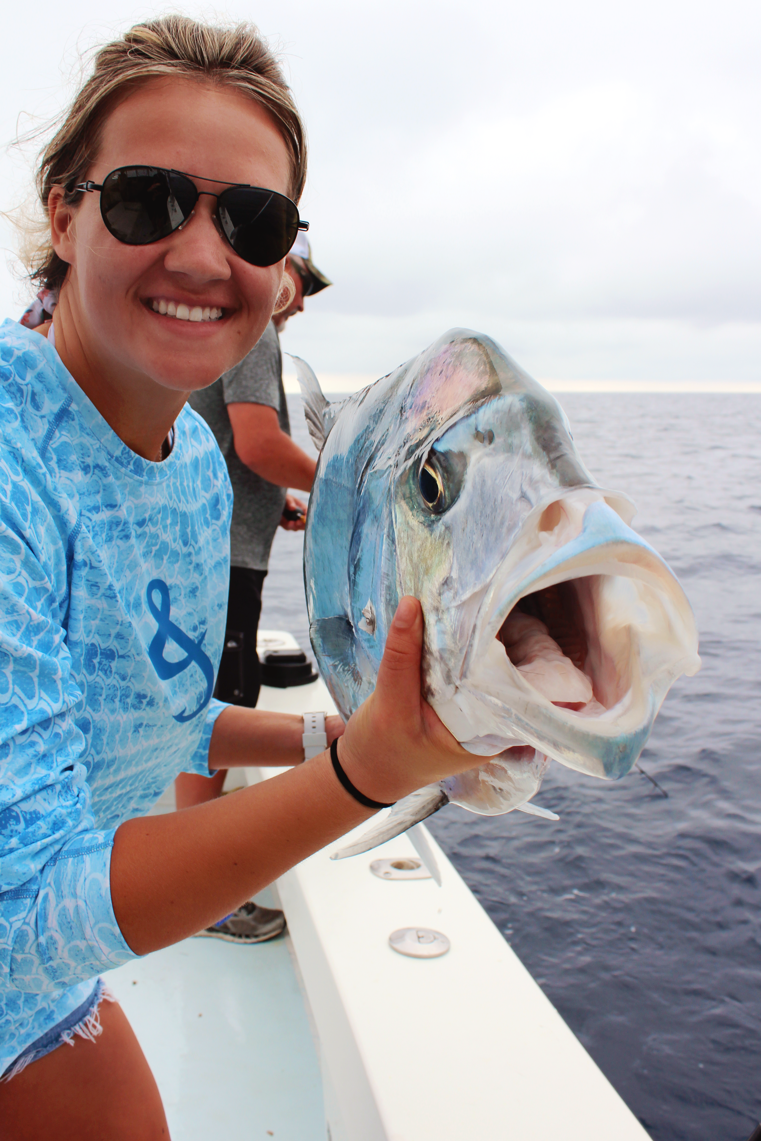 Smiling woman holding an African Pompano