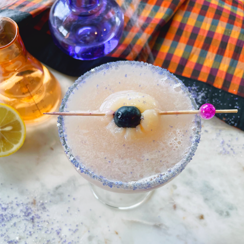 lavender pisco sour, top view of eyeball garnish: a blueberry stuffed in a lychee