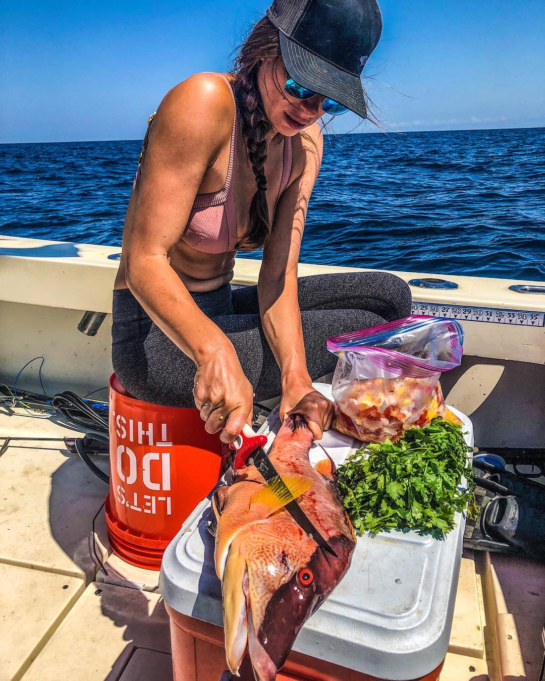 Valentine Thomas cutting up fresh caught fish on a boat