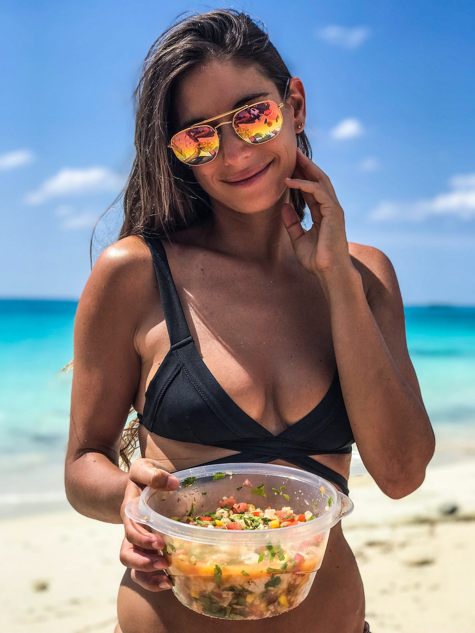 Valentine Thomas smiling holding clear bowl of her ceviche