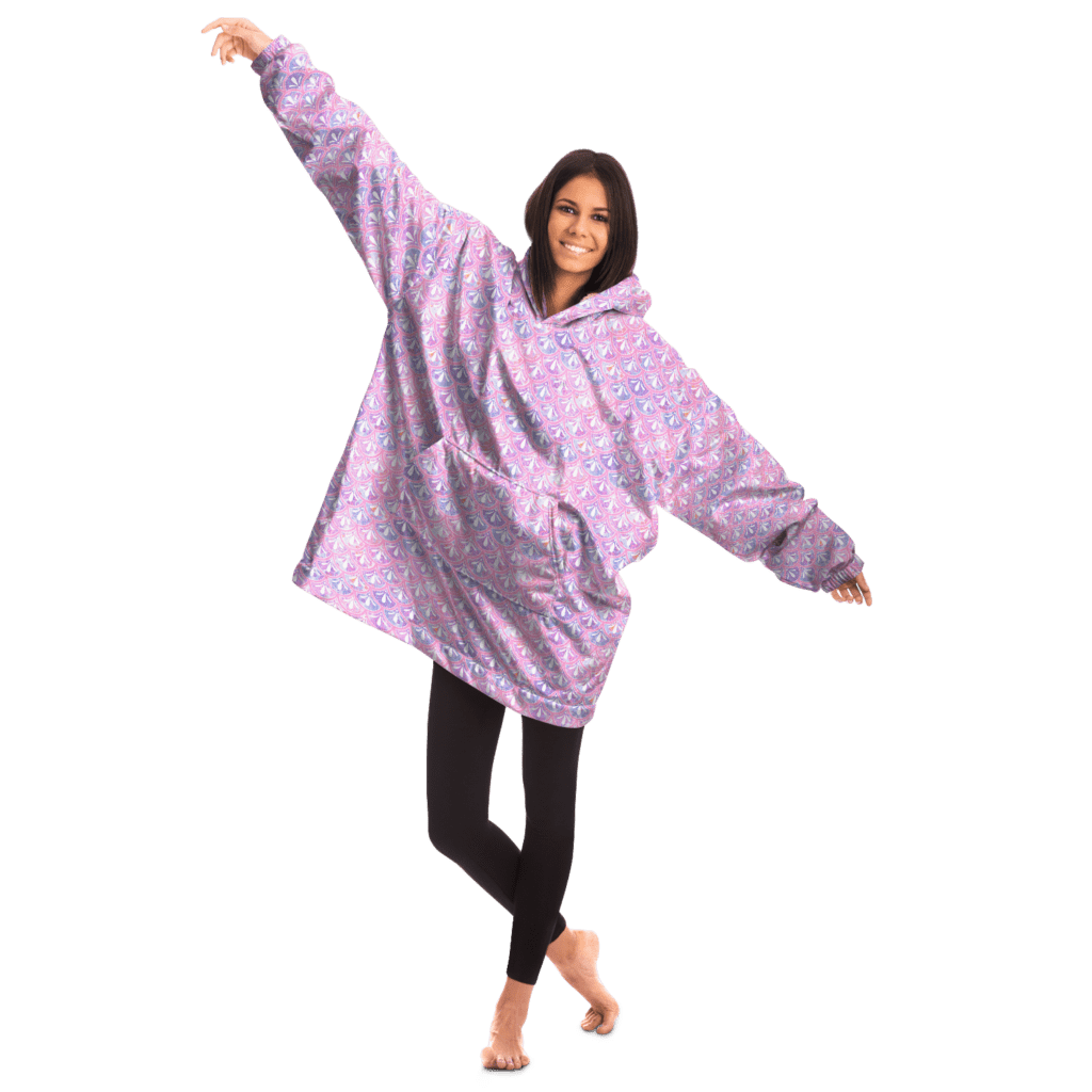 woman smiling with arms extended wearing a pink marbled blanket hoodie in a mermaid print