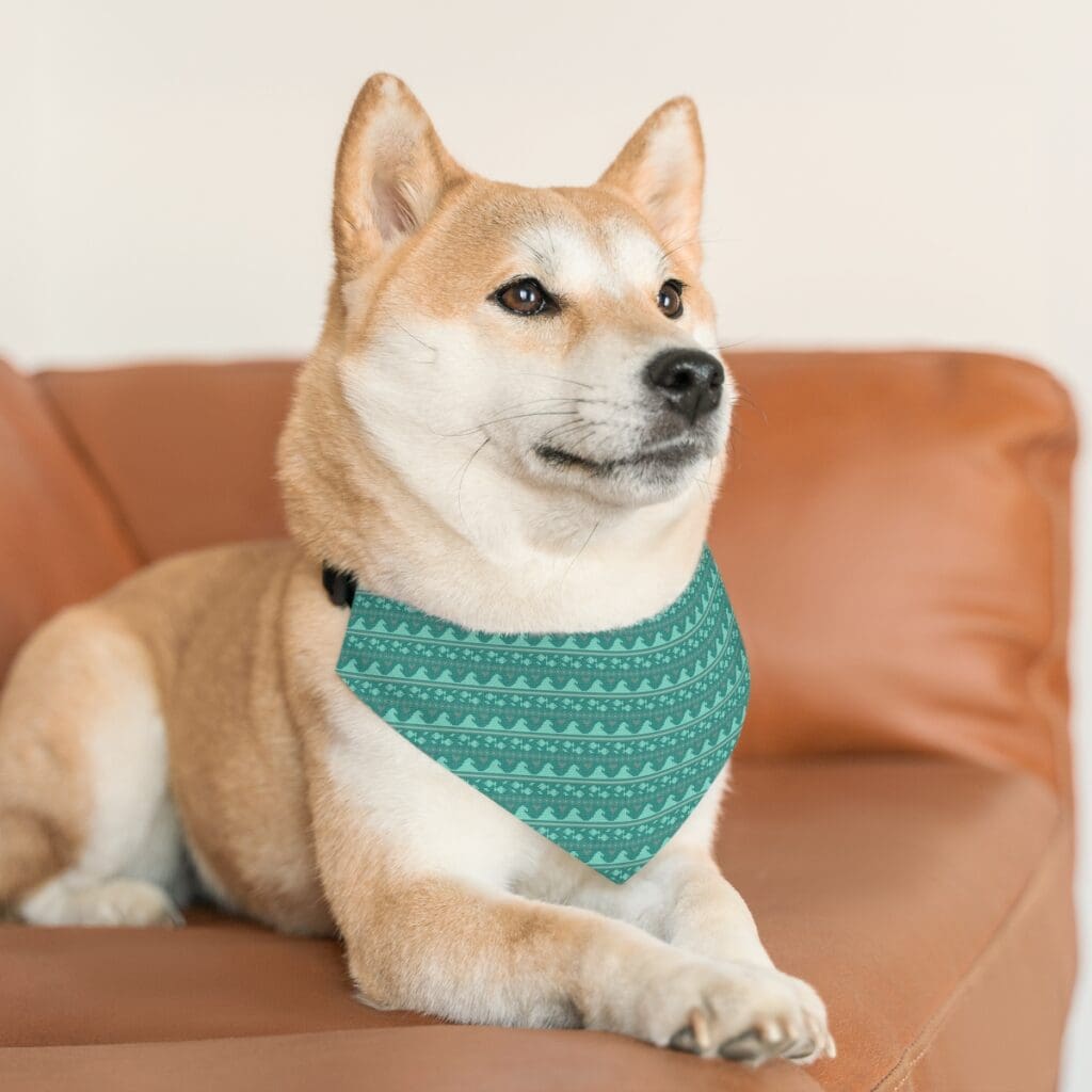 Relaxed, light colored dog wearing a green holiday bandana collar