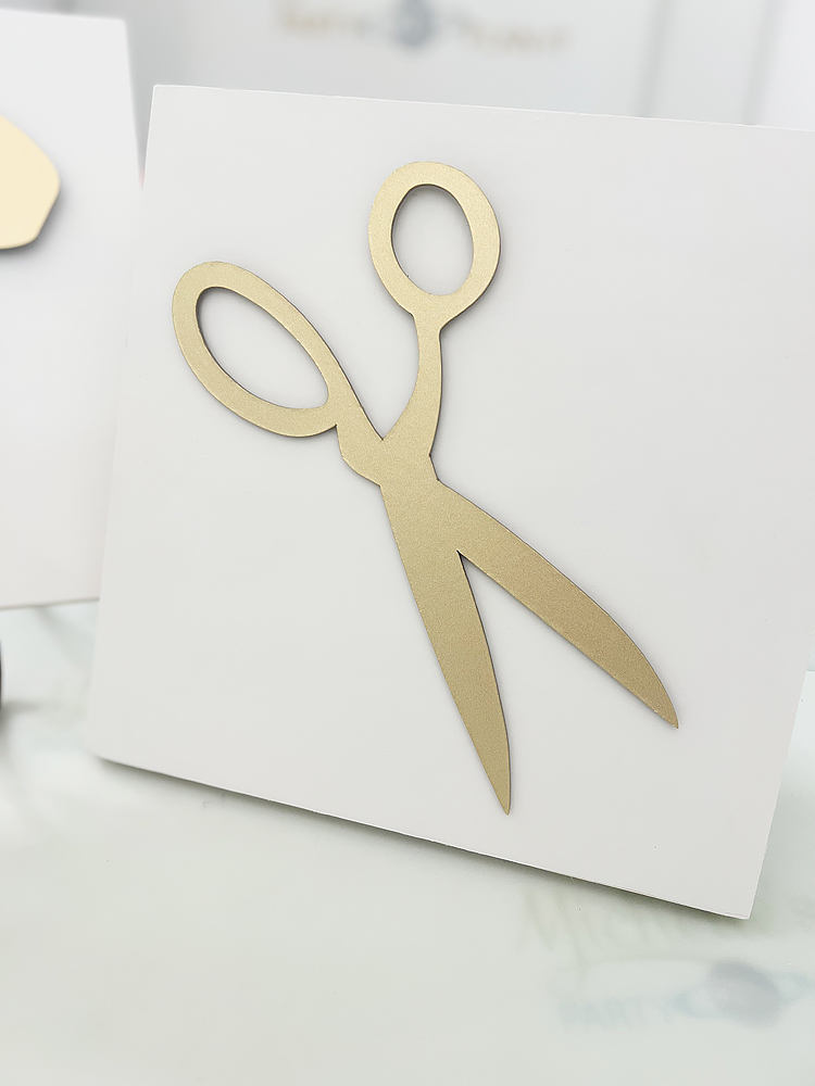 White square sign with gold scissors made with a Cricut