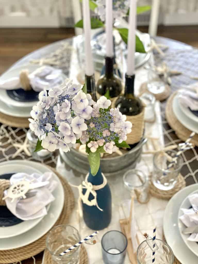 Coastal thanksgiving centerpiece with blues flowers and wine bottle candles